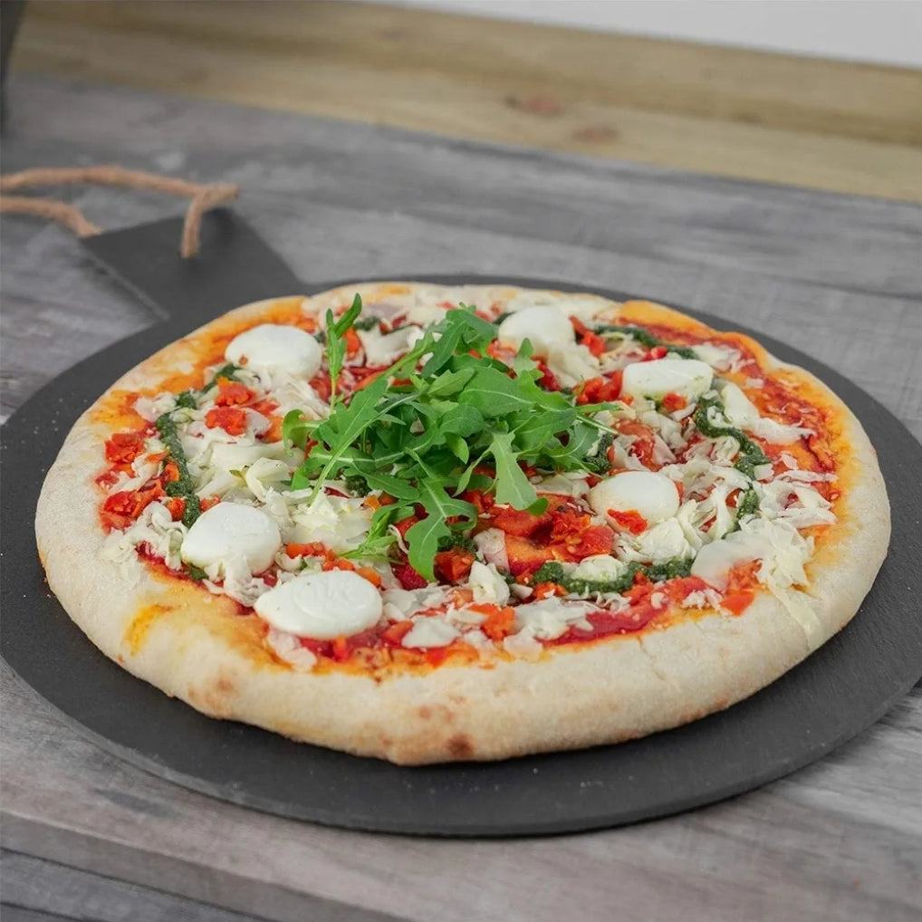 Pizza with arugula and mozzarella on a stone pizza peel