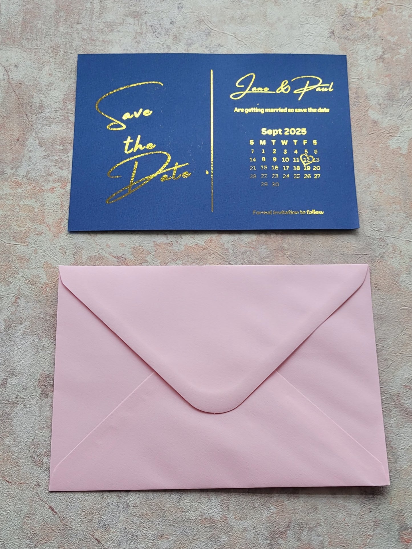 Save the date blue card with gold writing and light pink envelope