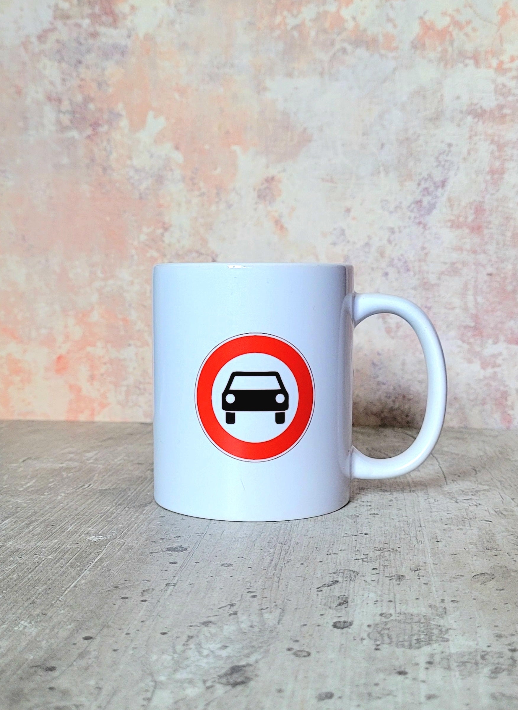 Rear view of mug with UK car symbol road sign design