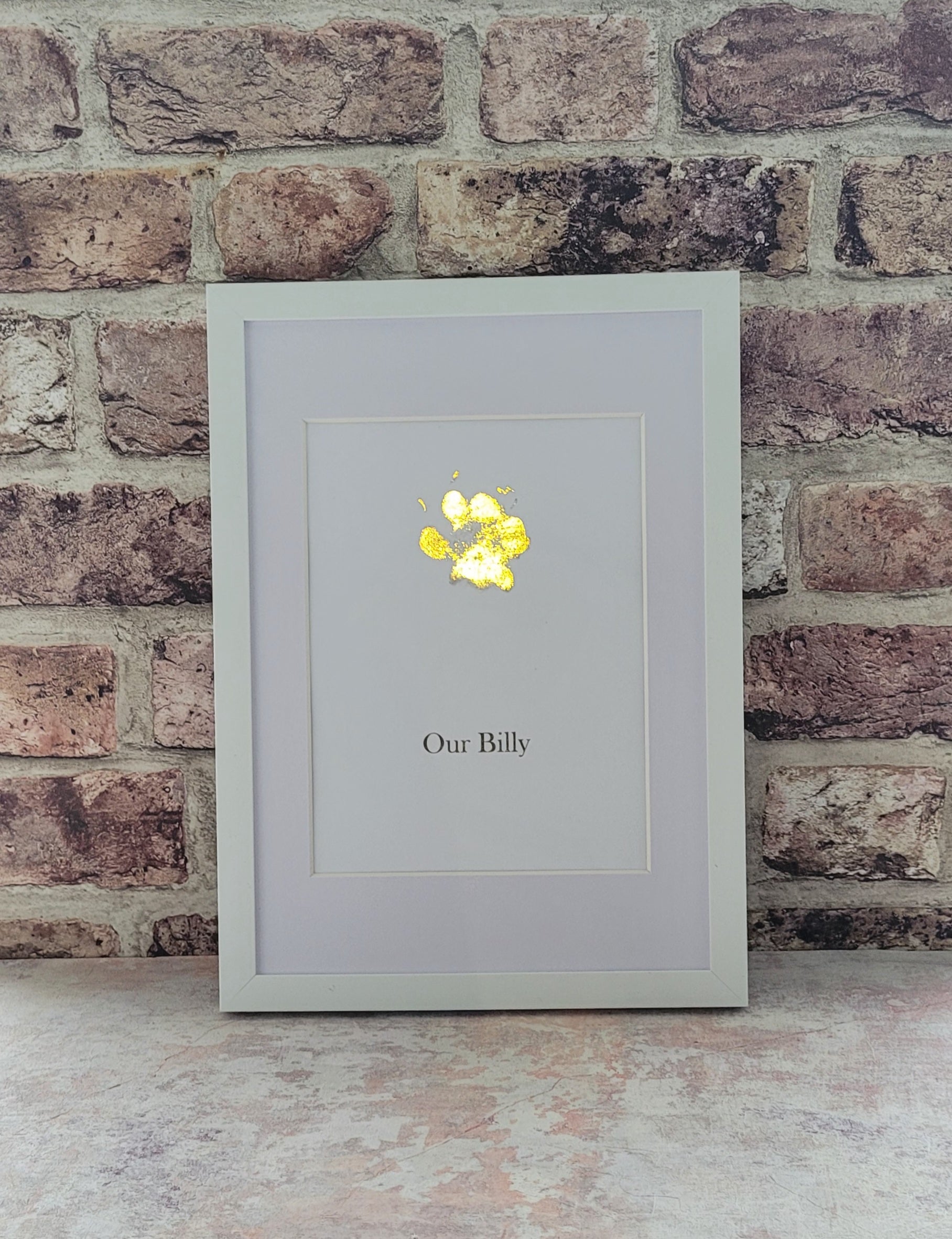 A4 Framed Pet Paw Print, personalised and printed in gold foil framed in a white acrylic frame behind glass 