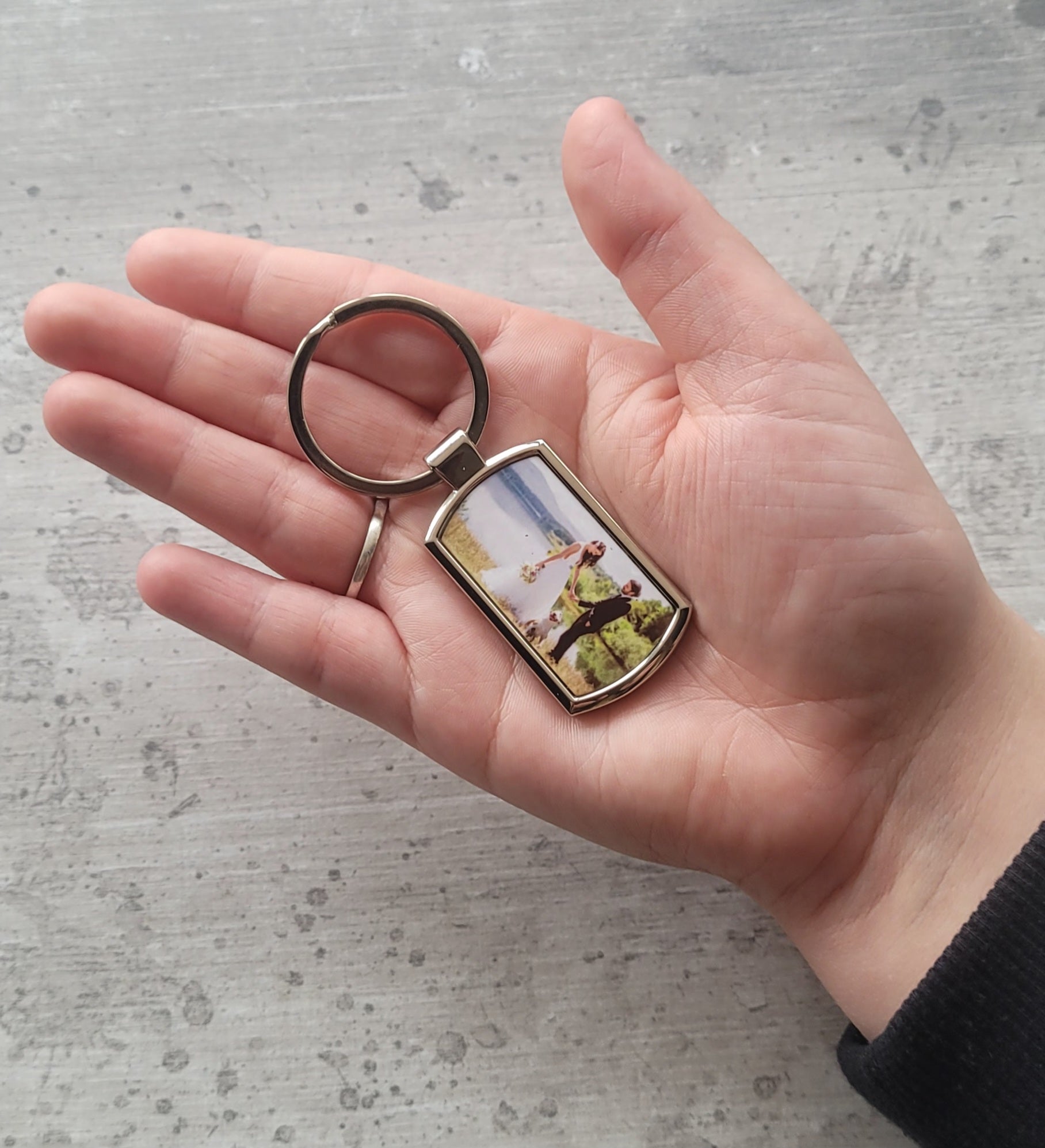 Personalised photo keyring in hand for size reference
