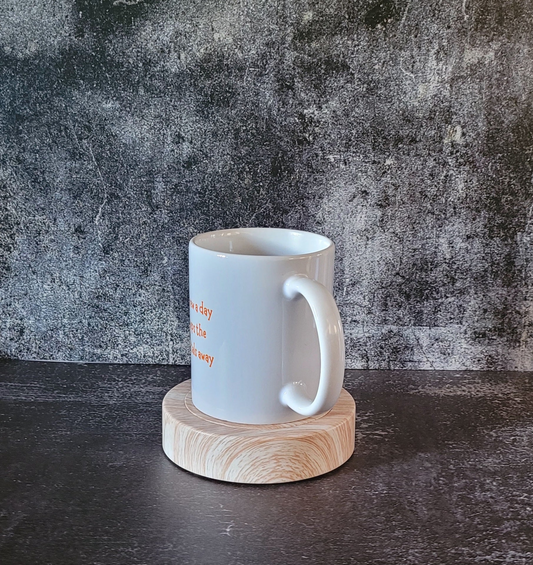 White mug on wooden coaster, dark textured background