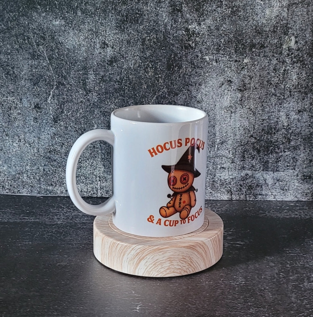 Front of mug showing witch hat doll and orange lettering.