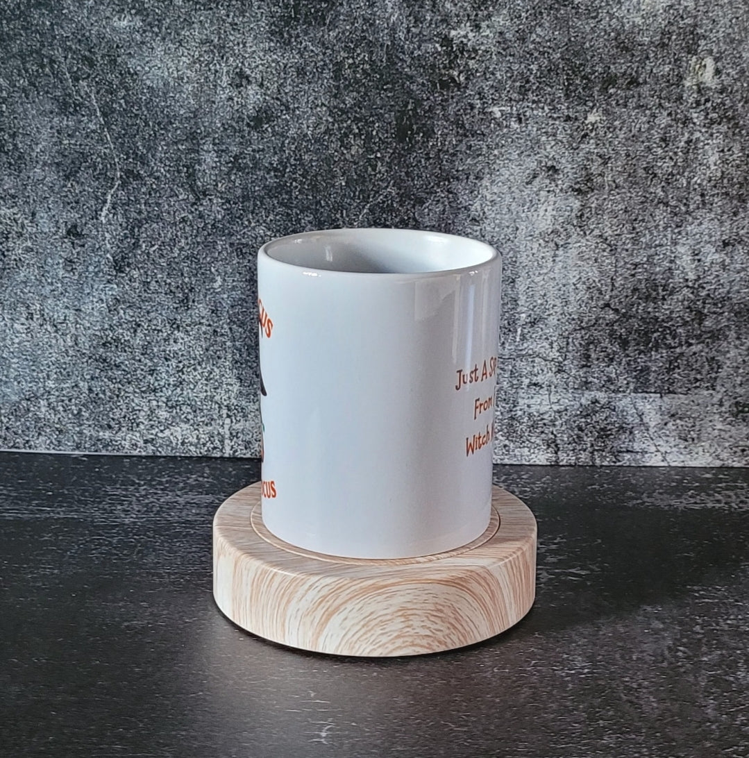 Halloween coffee cup on wooden coaster with gothic backdrop.