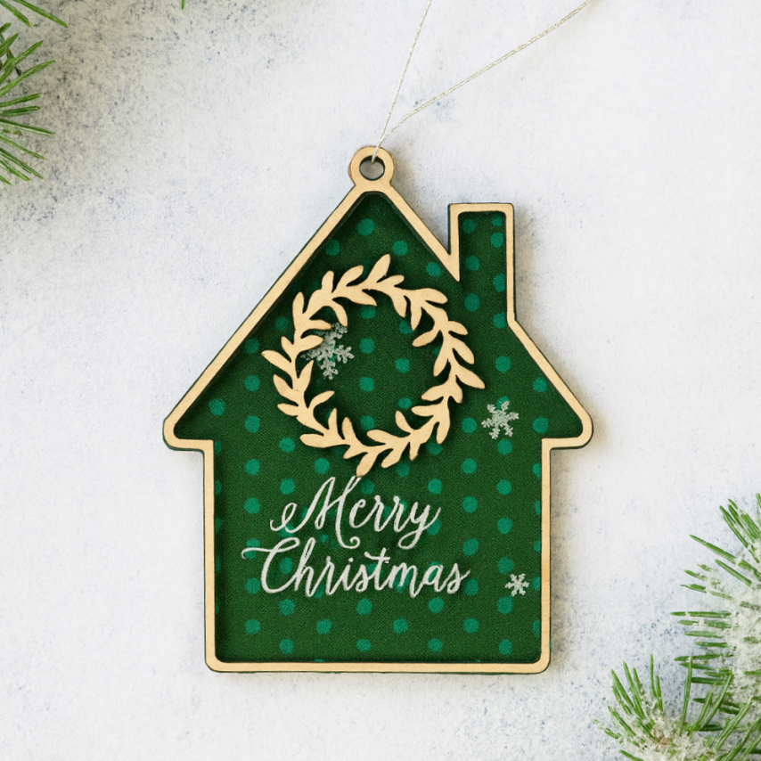 Green house ornament with wreath and Merry Christmas text.”