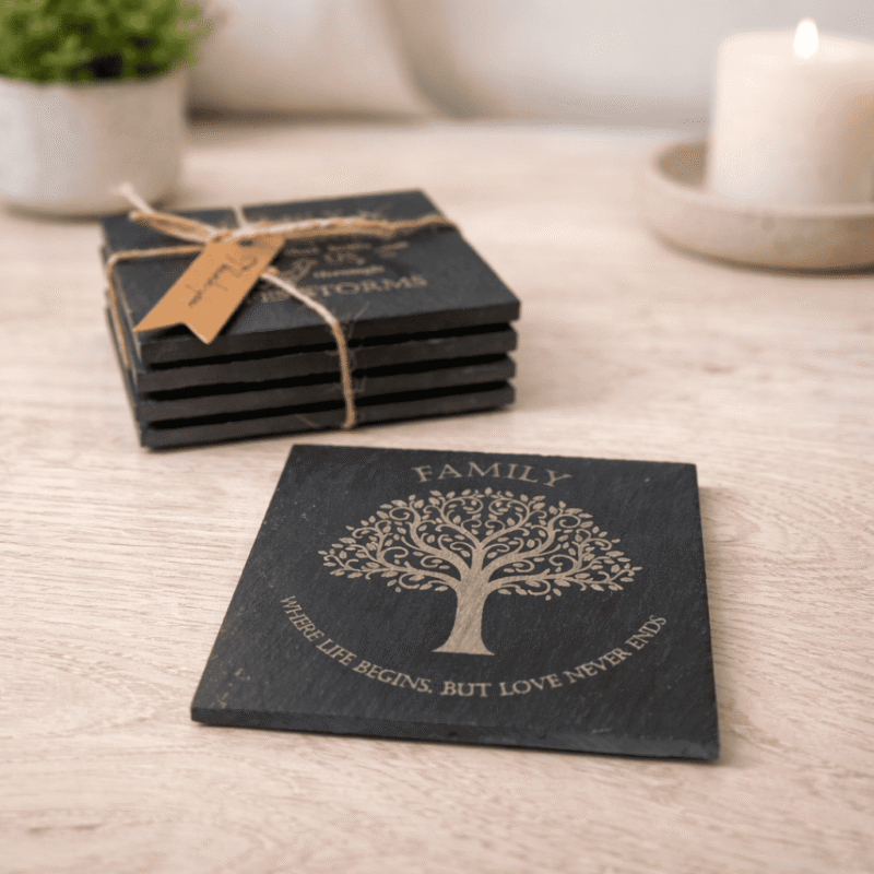 Family tree engraved slate coaster with quote “Where life begins but love never ends” shown with stacked coasters in background.