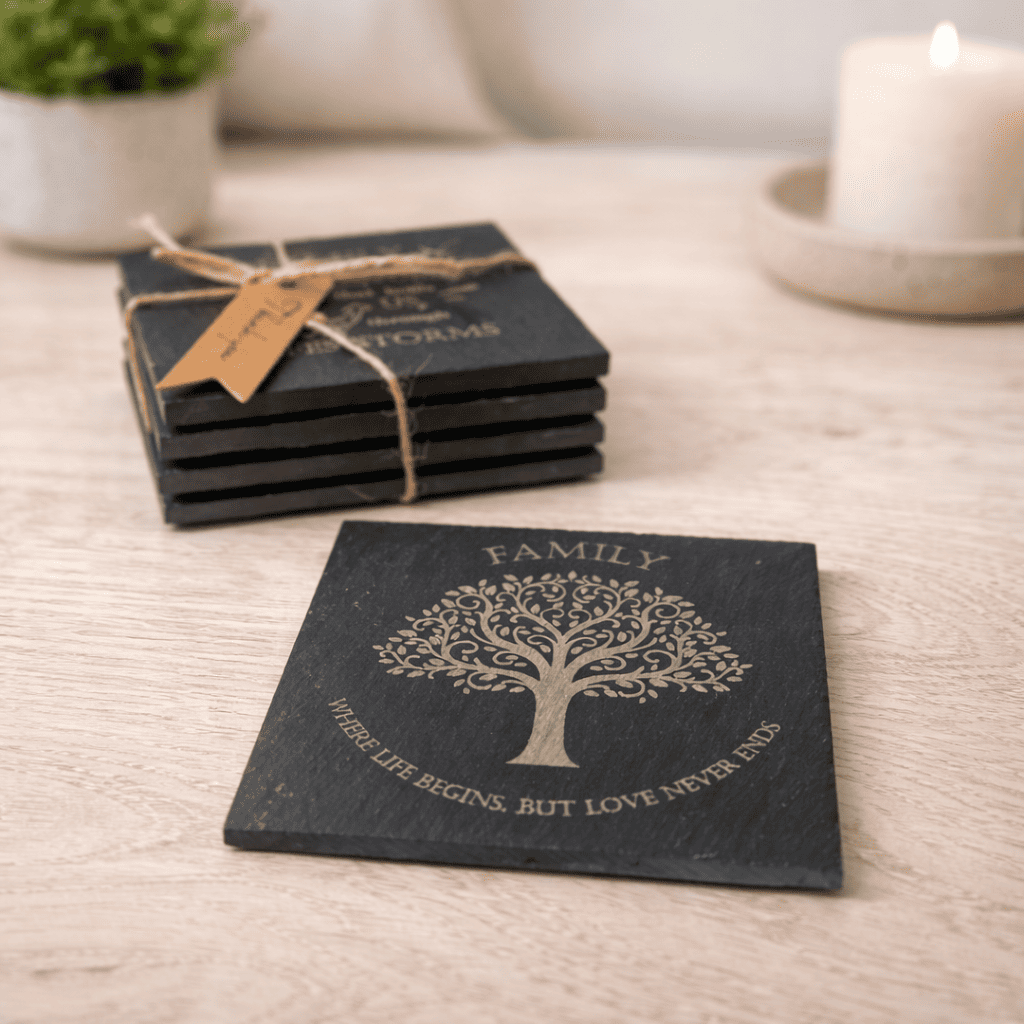 Family tree engraved slate coaster with quote “Where life begins but love never ends” shown with stacked coasters in background.
