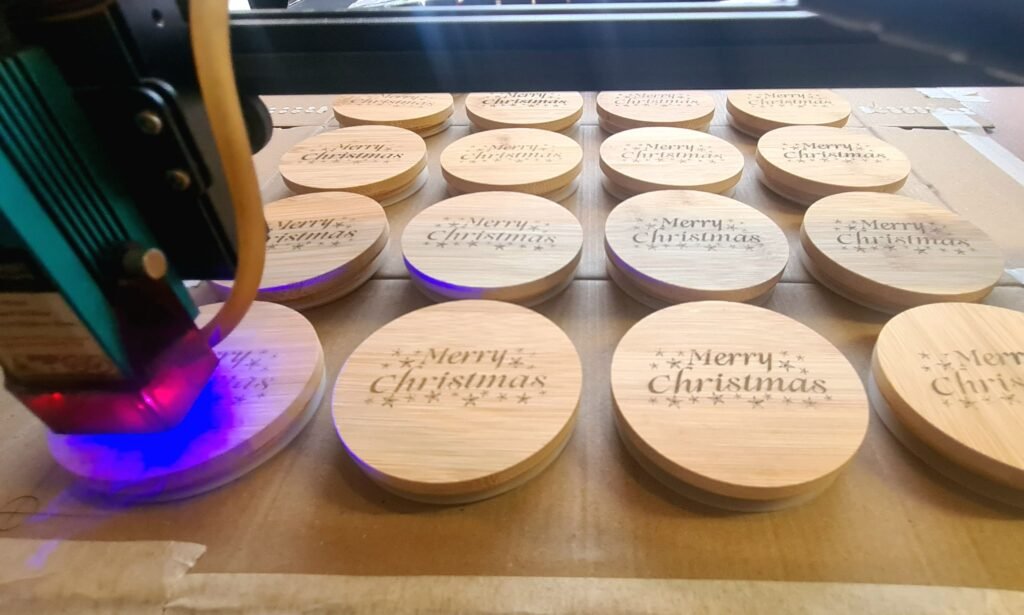 laser engraving machine full of engraved bamboo lids in a wood workshop for corporate engraving designs photo