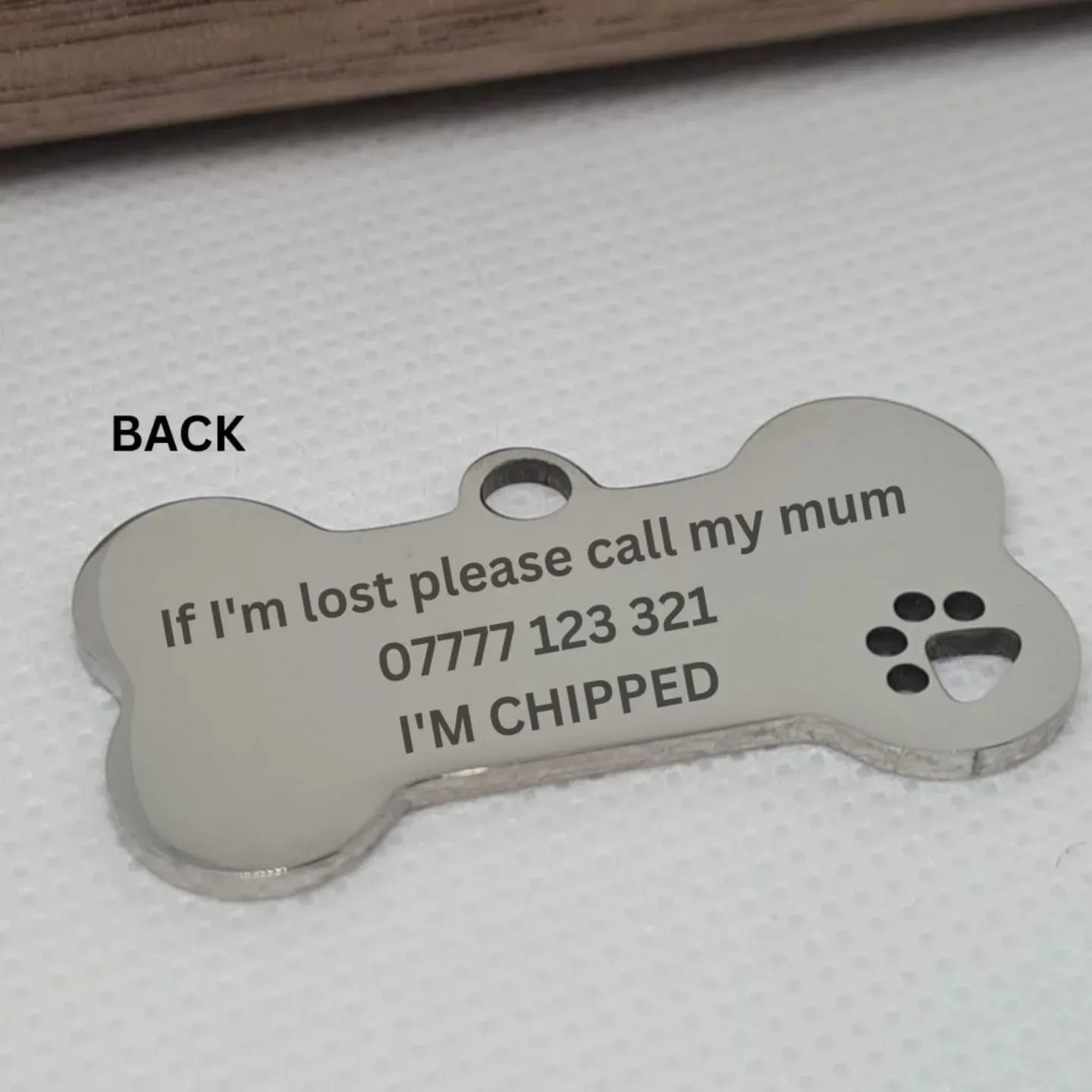 engraved stainless steel dog tag showing owner details