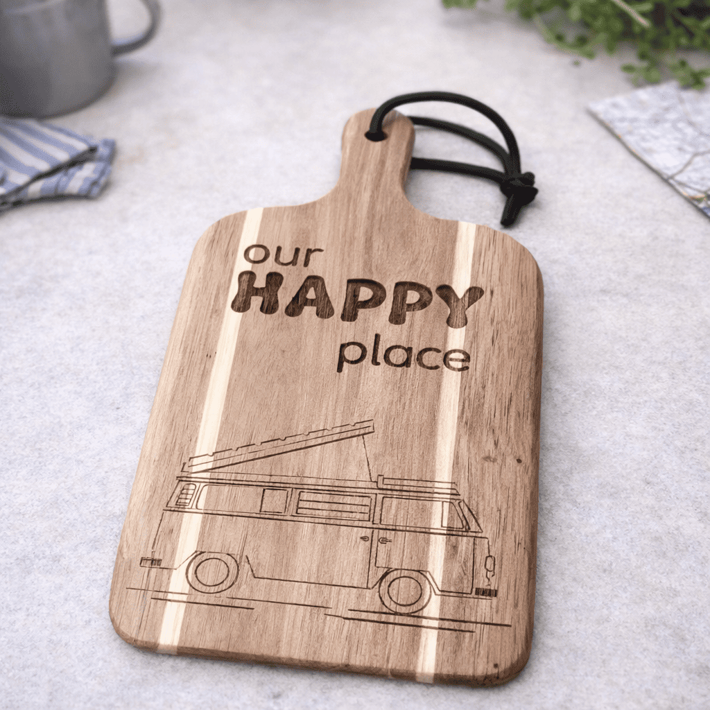 custom chopping board with a vw campervan engraved into the board with the writing our happy place