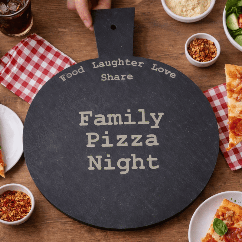 Family pizza night scene with engraved slate pizza board sharing food personalised kitchen gift UK