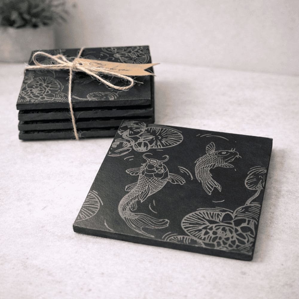 Engraved slate coasters featuring detailed koi fish designs, a handmade gift for fishing lovers and fish enthusiasts.