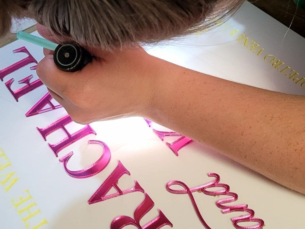 Hand finishing a personalised acrylic sign with raised mirrored lettering, showing the care and attention to detail behind gifts handmade by Laser Guided Gifts.
